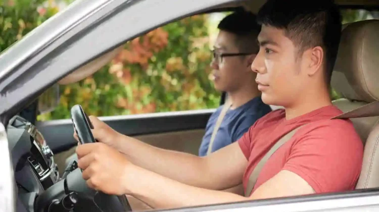 A man in red shirt taking his test drive with an examiner