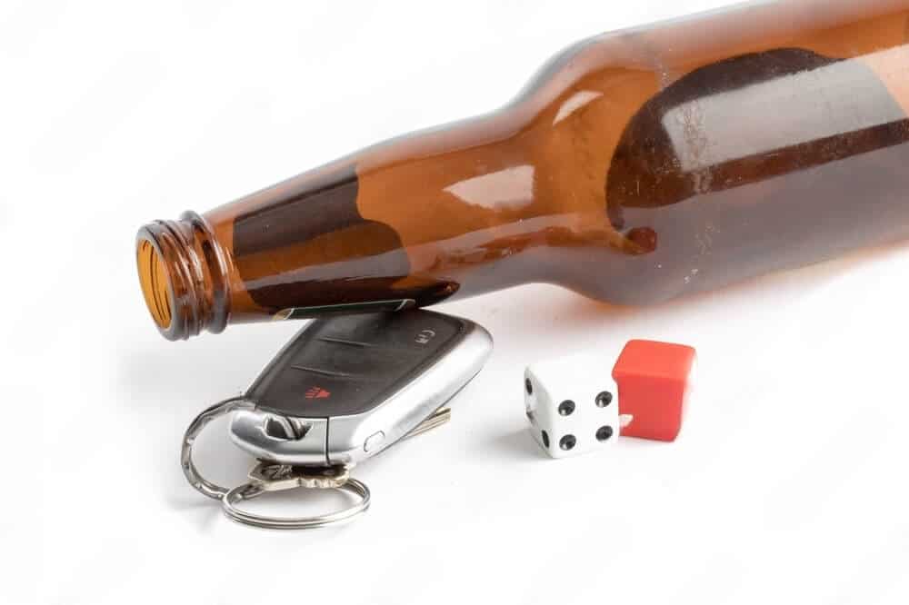 An alcohol bottle and a car key showing symptoms of a buzzed driving definiton